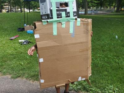 young kid in a cardboard robot costume.