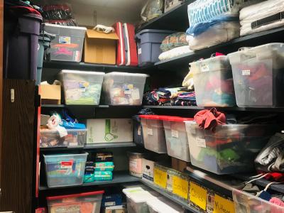 Storage closet with floor to ceiling shelves filled with plastic bins